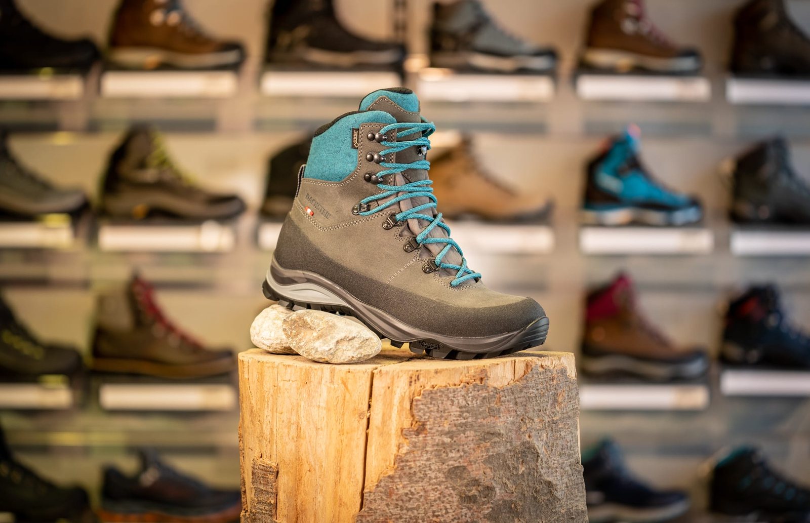 Wanderschuh auf dem Holzpodest vor der Schuhwand im Sportshop am Markt